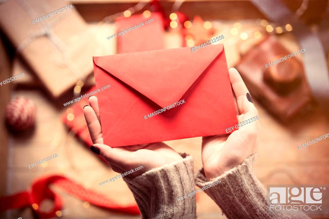 Stock Photo: beautiful woman hands holding big red envelope on the wonderful decoration background.