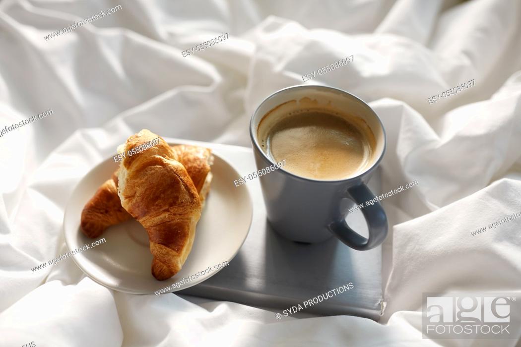Stock Photo: croissants, cup of coffee and book in bed at home.