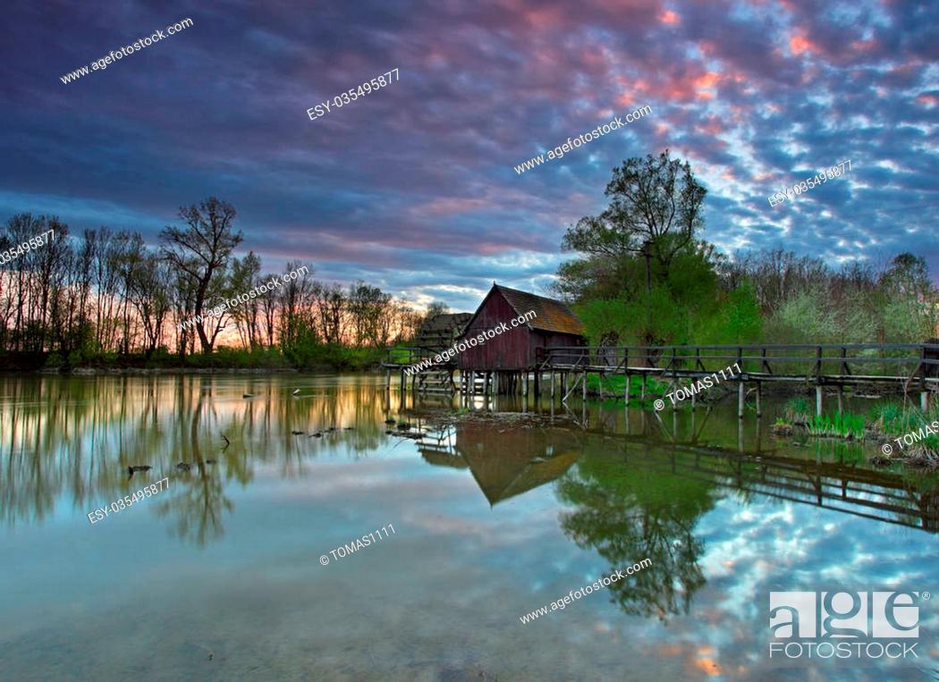 Stock Photo: Summer landscape with river and watermill with dramatic sunset.