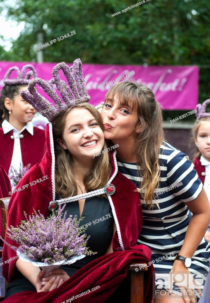 Stock Photo: 18-year-old Marie-Louisa Sebastian (m) smiles with her sister and heather queen of 2013, Lara-Sophie Wedekind (r), after her election as the new heather queen.