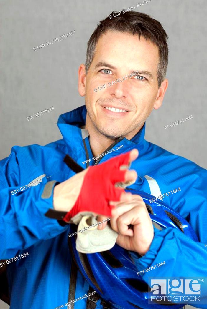 Stock Photo: Cyclist Puts On His Gloves.