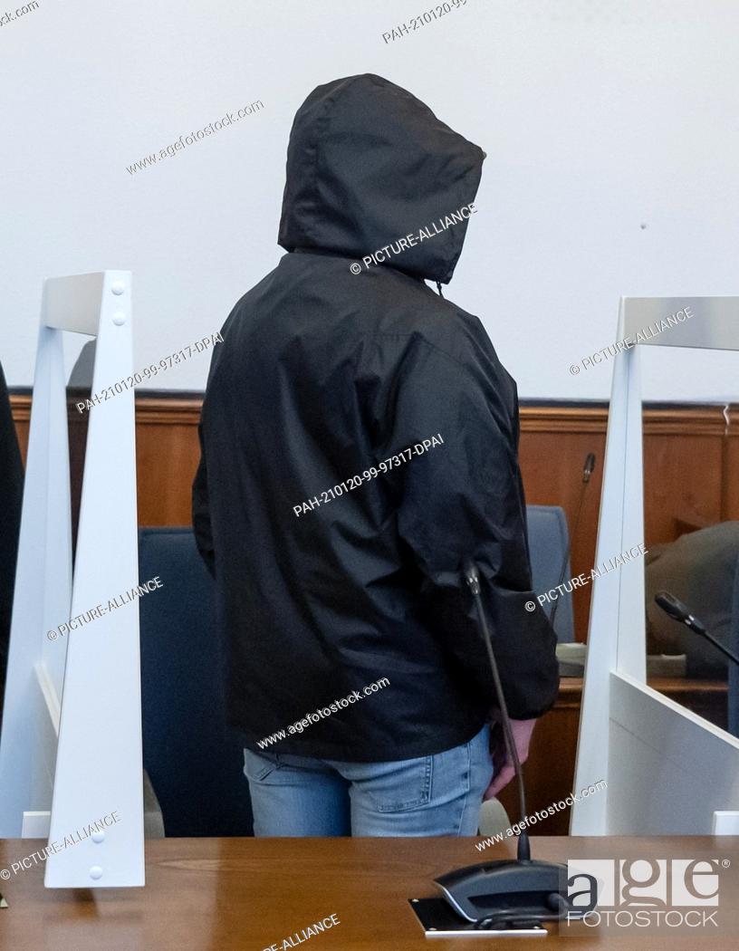 Stock Photo: 20 January 2021, North Rhine-Westphalia, Dortmund: The defendant stands in the district court at his place between Plexiglas panes to protect against infection.