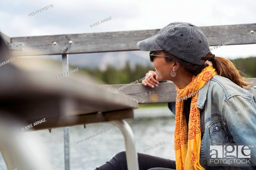 Stock Photo: Finland, Lapland, smiling young woman on jetty at the lake.