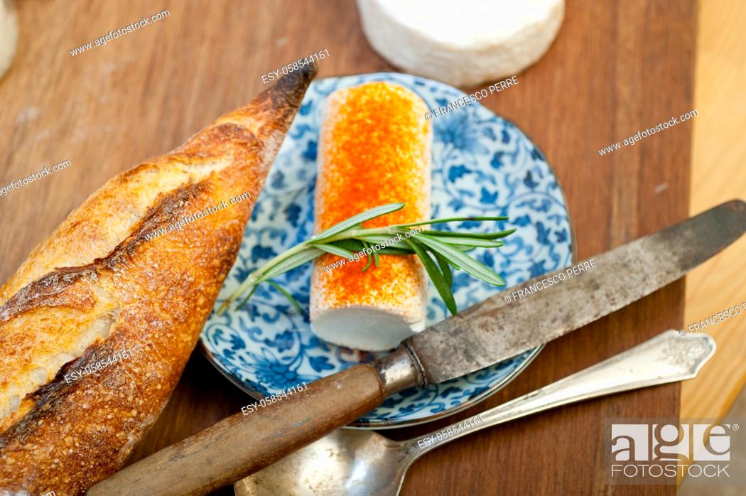 Stock Photo: French cheese and fresh baguette on a wood cutter.
