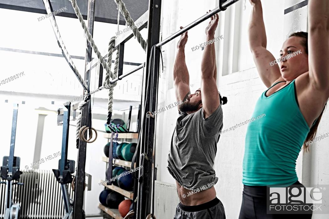 Stock Photo: Couple doing chin-up in cross training gym.