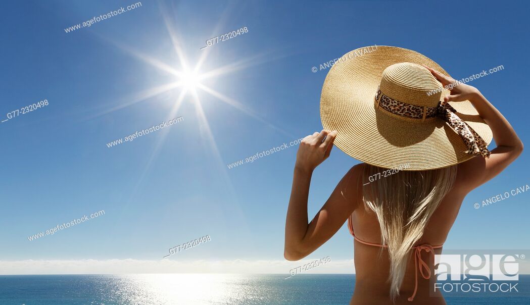 Stock Photo: Woman with hat on the beach under sunshine.
