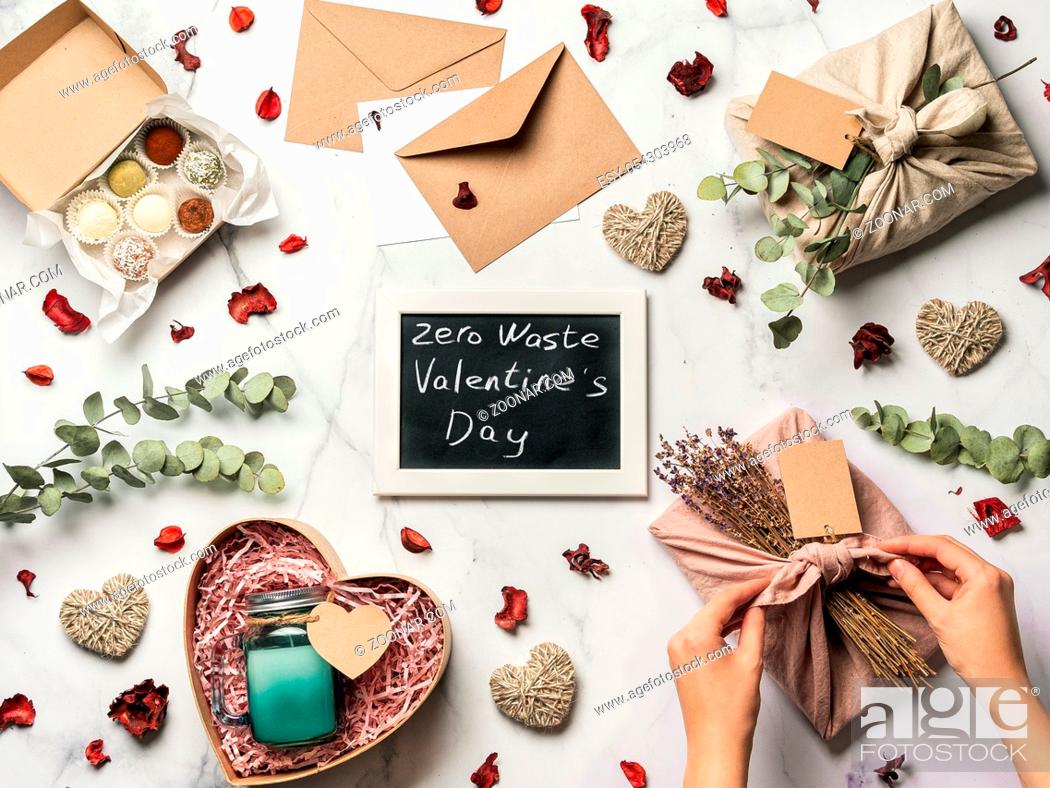Imagen: Zero waste Valentine's Day concept. Eco-friendly gift cloth wrapping in Furoshiki style, homemade sweets and candle as gift ideas and chalkboard with Zero Waste.