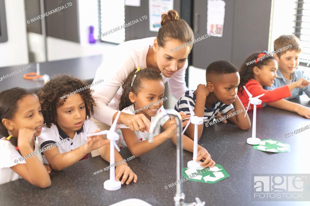 Stock Photo: High angle view of teacher explaining about windmill to school kids at school in classroom.