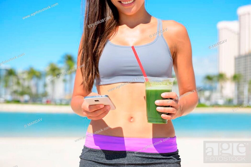 Stock Photo: Woman drinking vegetable Green detox smoothie using smart phone after fitness running workout on summer day. Fitness and healthy lifestyle concept with.