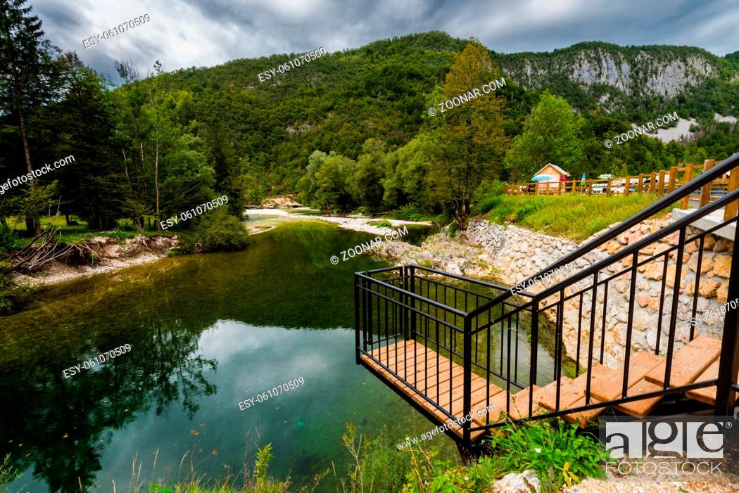 Stock Photo: Wooden skywalk viewpoint over Small river with white round stones on the riverbanks in the Triglav National Park in Slovenia on cloudy autumn day.