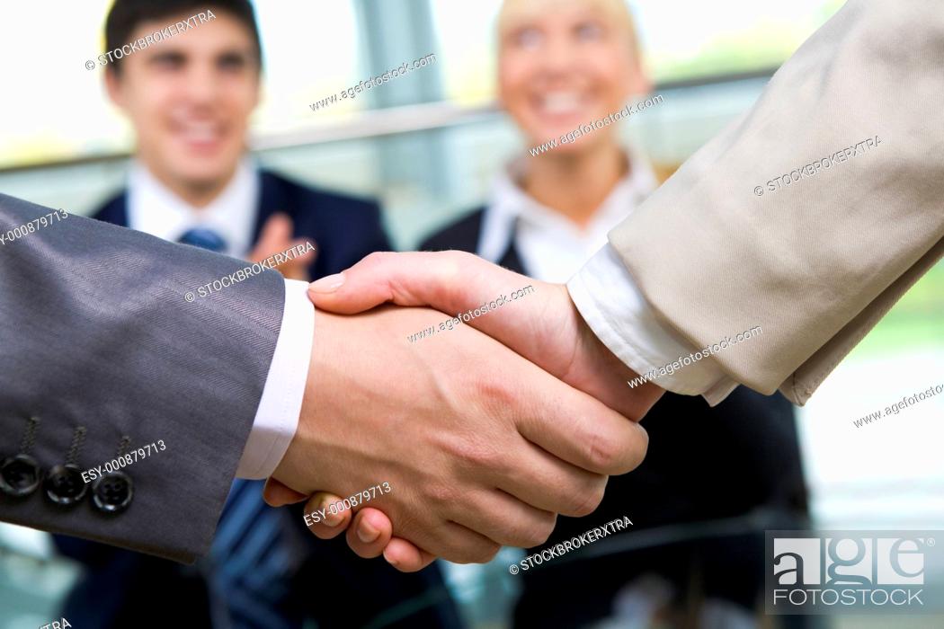Stock Photo: Photo of handshake of business partners on background of happy people.