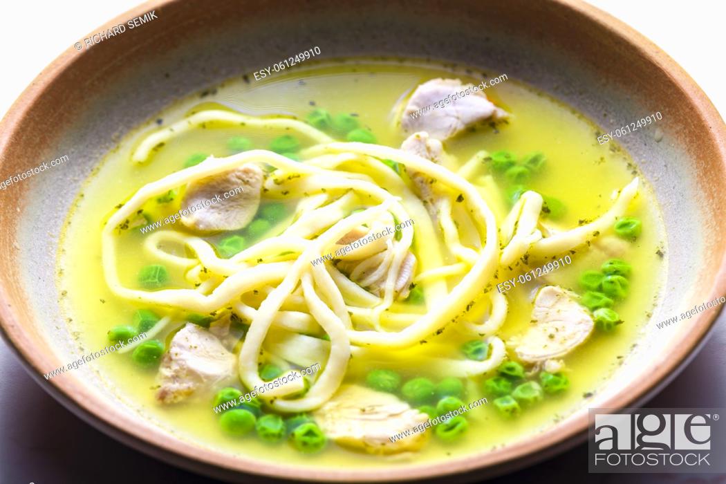 Stock Photo: chicken broth with green peas and noodles.