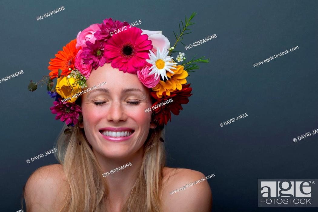 Stock Photo: Young woman wearing garland of flowers on head.