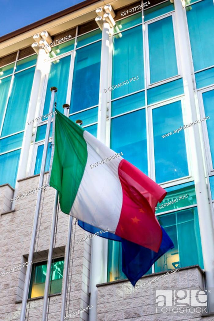 Stock Photo: Italian flag hoisted with modern building on the background.