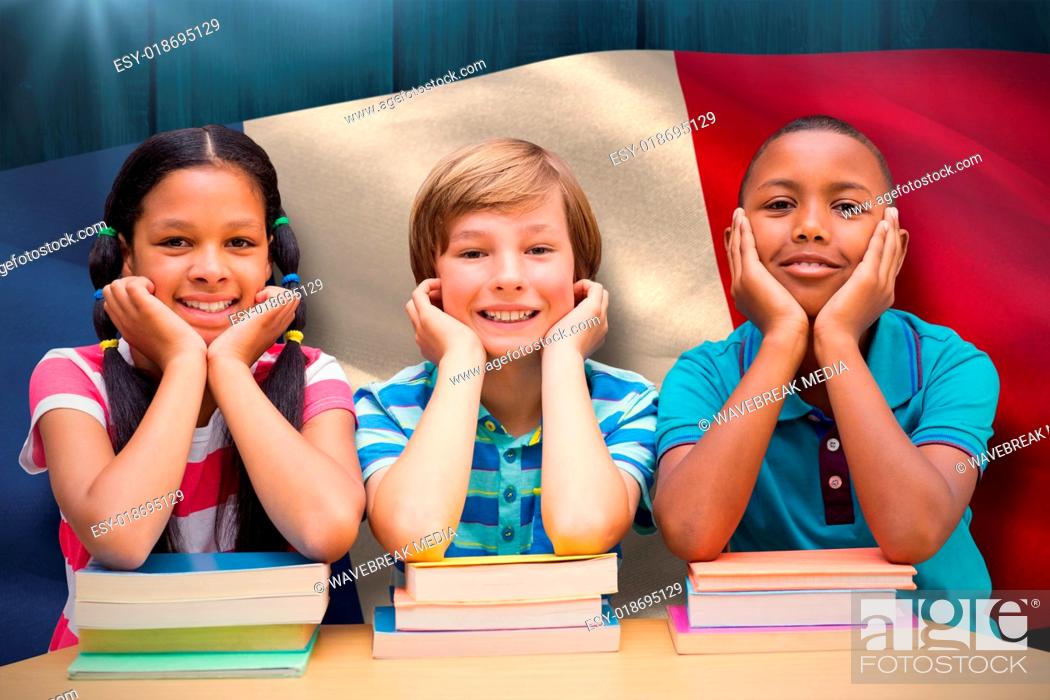 Stock Photo: Composite image of cute pupils looking at camera in library.