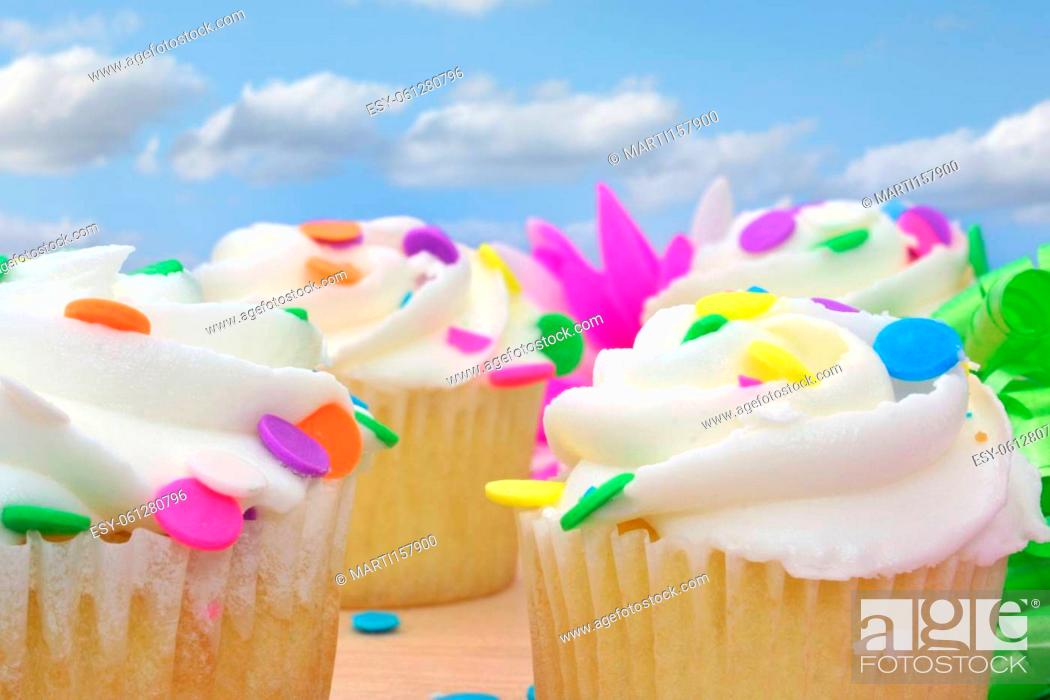 Stock Photo: Cupcakes and Flower with Beads and Ribbon on Wooden Table.