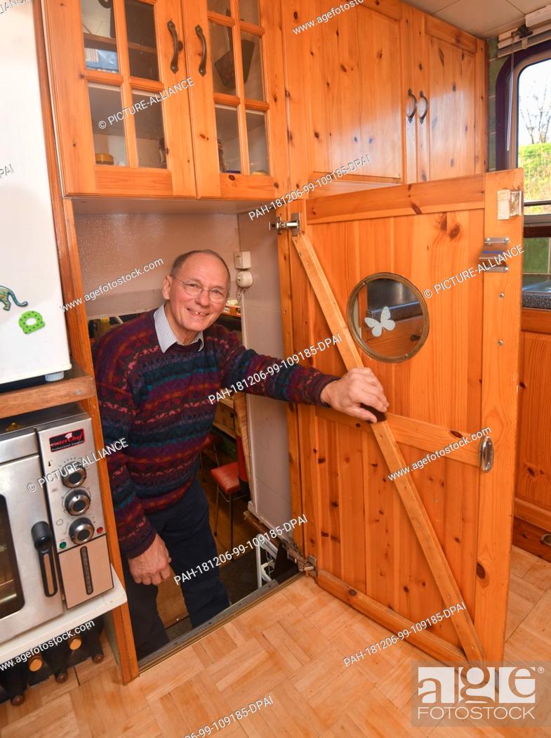 Stock Photo: 04 December 2018, Brandenburg, Kienitz: Paul Kamstra, a globetrotter from the Netherlands, comes from the lower deck of his ship.