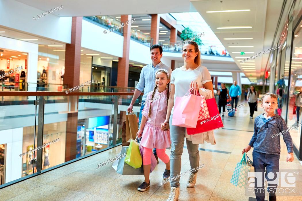 Stock Photo: Glückliche Familie mit vielen Einkaufstüten beim Shopping im Einkaufszentrum.
