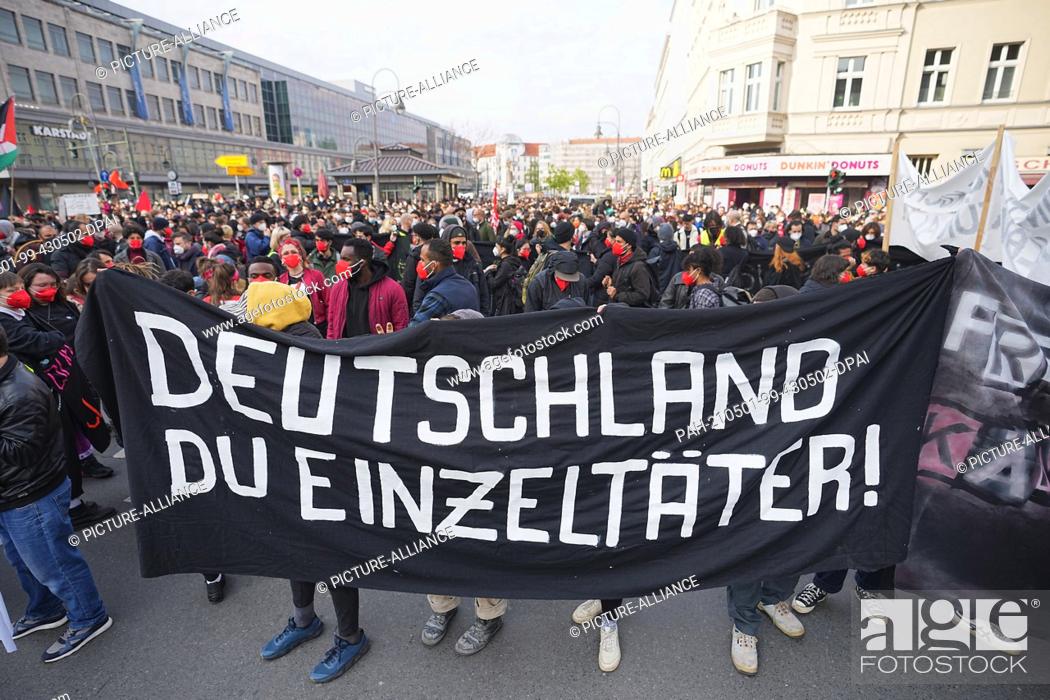 Stock Photo: 01 May 2021, Berlin: ""Germany you lone perpetrator!"" is written on the banner held by participants in the demonstration march of left-wing and radical.