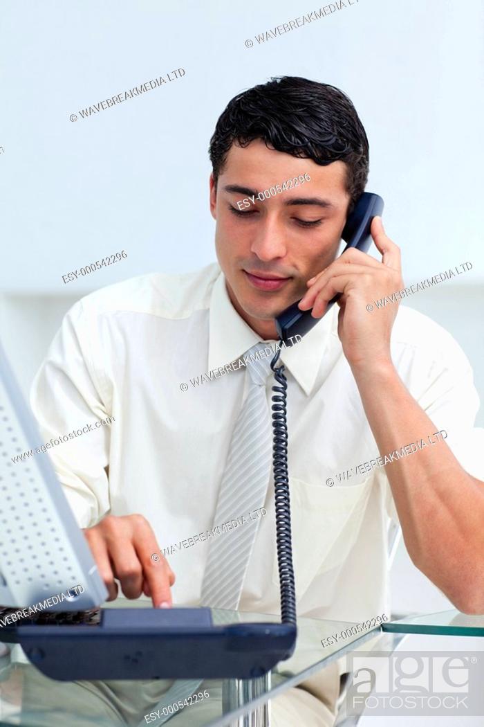 Stock Photo: Concentrated Hispanic businessman on phone at work.