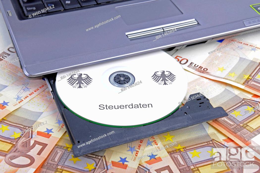 Stock Photo: CD labelled Steuerdaten, German for tax data in a computer drive, 50 euro notes, symbolic image for illegal trade with tax data, breach of data protection.