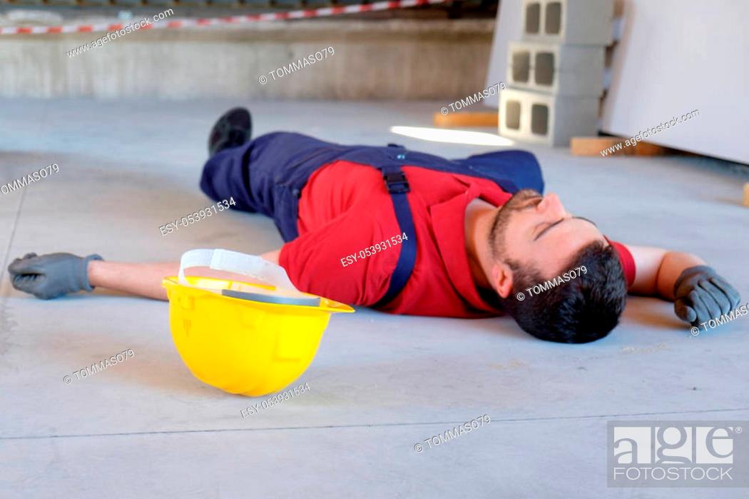 Stock Photo: Worker in a faint after on-the-job injury, main focus on the helmet.