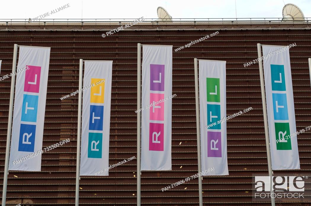 Stock Photo: 03 August 2021, Cologne: Flags of the TV channel RTL stand on the square in front of the company building. RTL Group presents its half-year figures on 05.