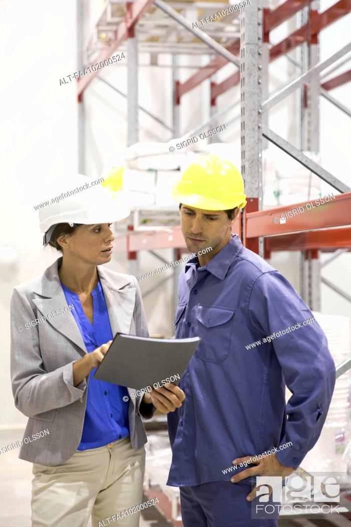 Stock Photo: Female manager speaking with warehouse worker.