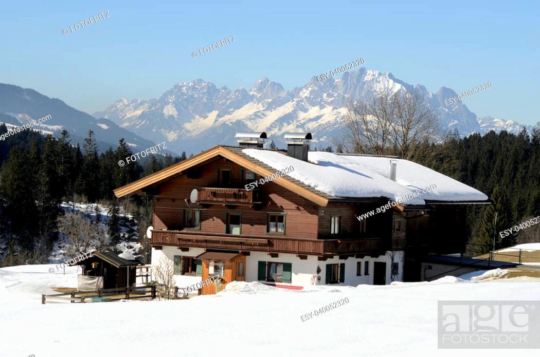 Stock Photo: Austria, home in Tirol in traditional structure, Wilder Kaiser (mountain) in background.