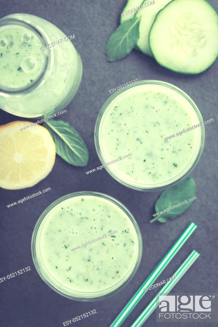 Stock Photo: Refreshing green cucumber, yogurt, mint and lemon smoothie in glasses, photographed overhead on slate (Selective Focus, Focus on the drinks) (Digitally Altered:.