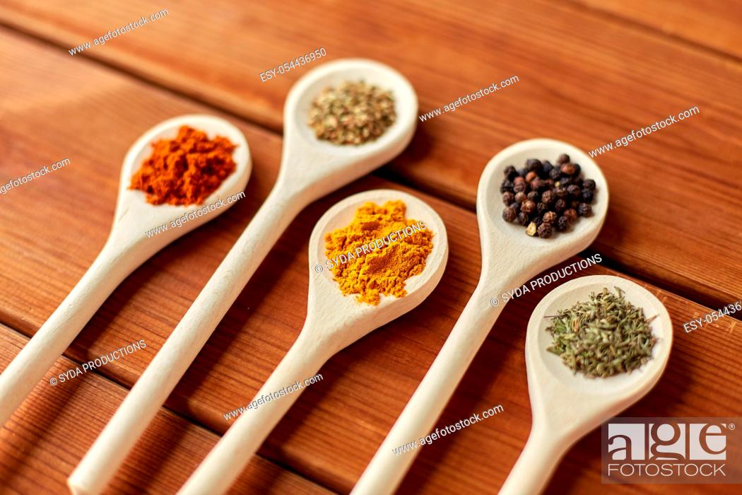 Stock Photo: spoons with different spices on wooden table.