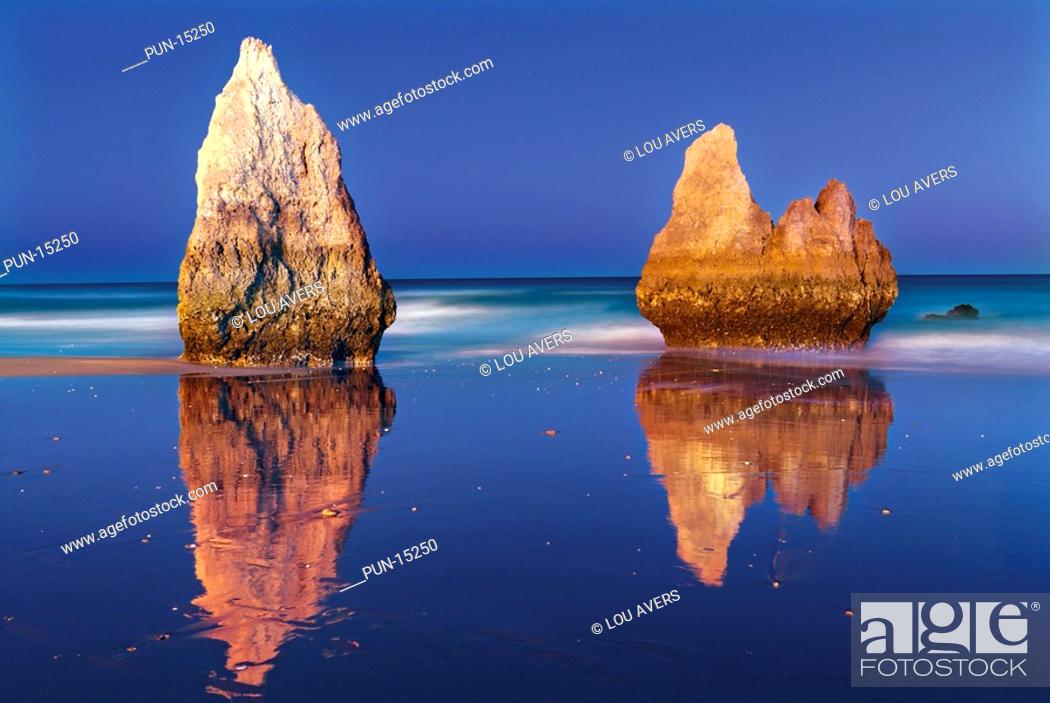 Stock Photo: Rocks and twilight at beach Praia dos Tres Irmaos in Alvor, Algarve, Portugal.