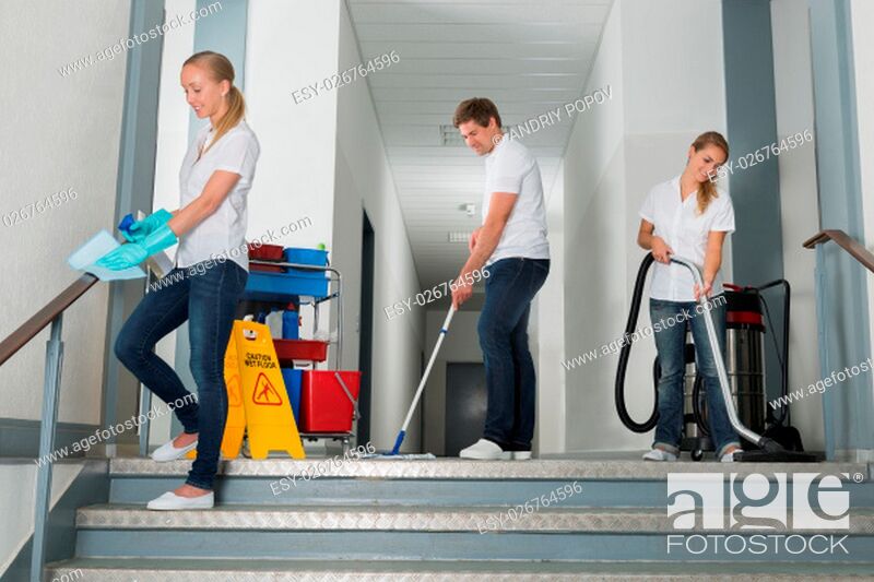 Stock Photo: Group Of Happy Male And Female Janitor Cleaning Corridor With Cleaning Equipments.