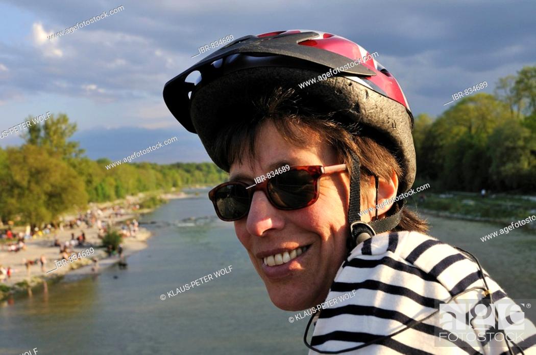 Stock Photo: Woman wearing sunglasses and bicycle helmet at the Flaucher, an offshoot of the Isar River, Munich, Upper Bavaria, Germany, Europe.