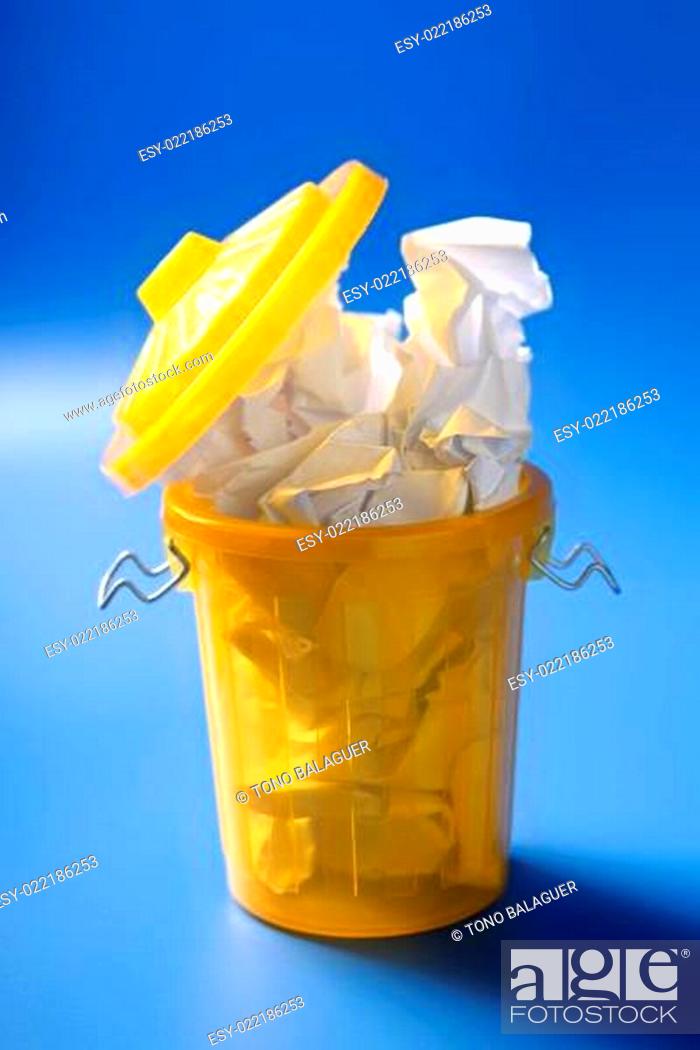Stock Photo: Paper trash in yellow over blue background.