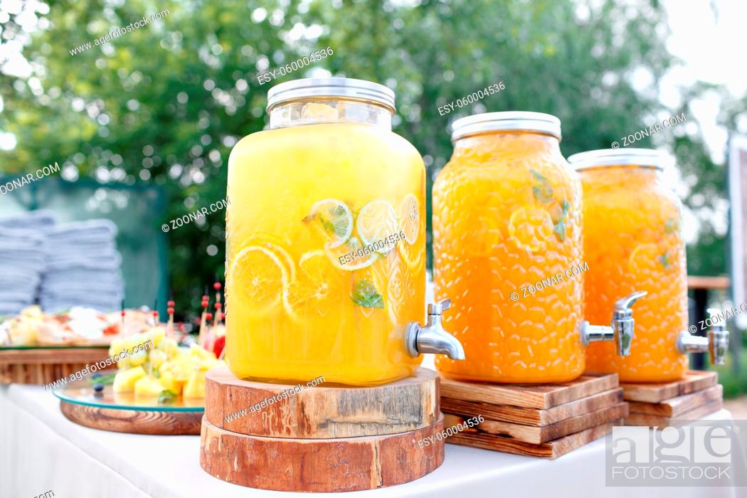 Stock Photo: Jar of tasty fresh lemonade with ice and mint. appetizers, canapes and bruschetta on background. the fourchette in the open air. professional catering.