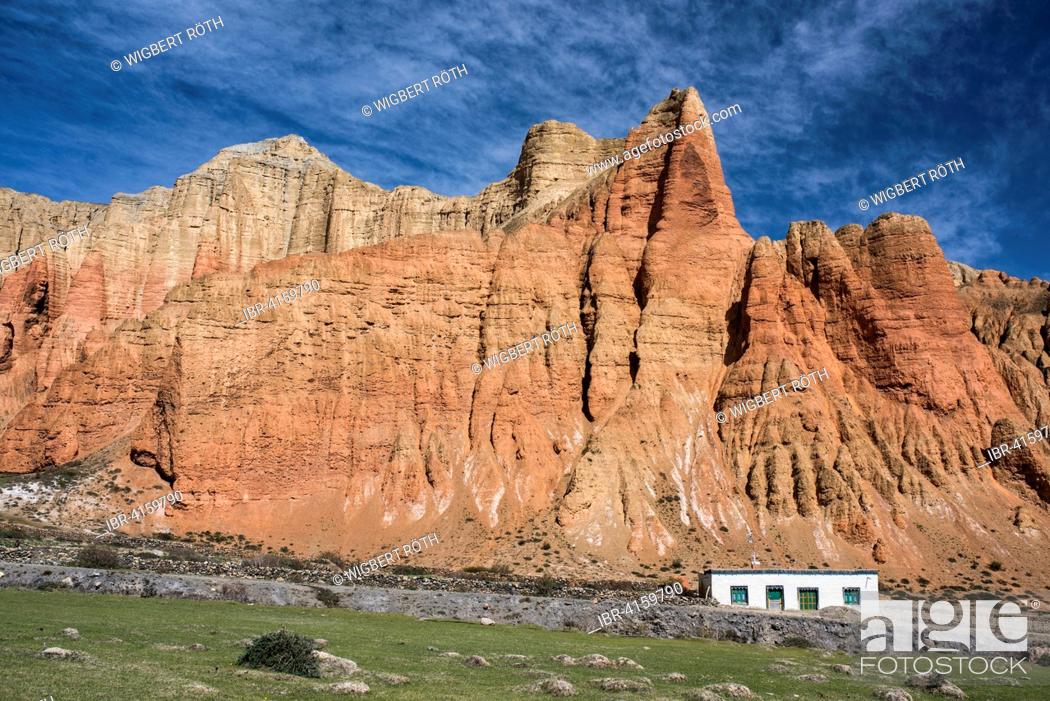 Stock Photo: Red rock formations, Red Cliffs with house in front of erosion landscape, Dhakmar, former Kingdom of Mustang, Nepal.