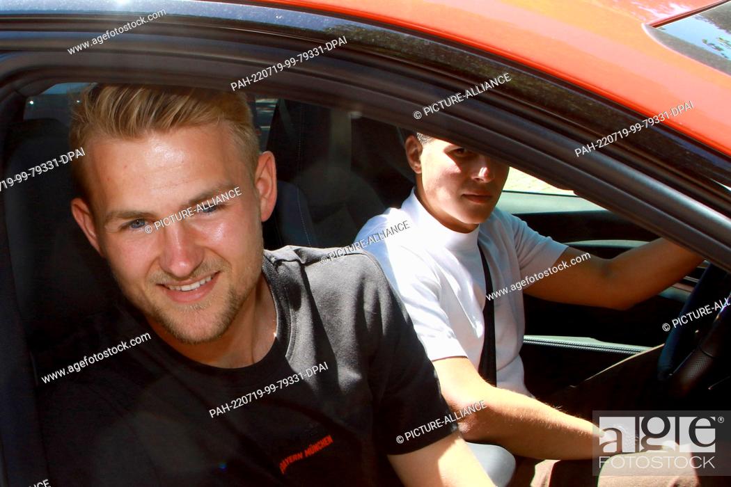 Stock Photo: 19 July 2022, Bavaria, Munich: Soccer player Matthijs de Ligt (l) smiles from the window of a car as he leaves the offices of Bundesliga club FC Bayern Munich.