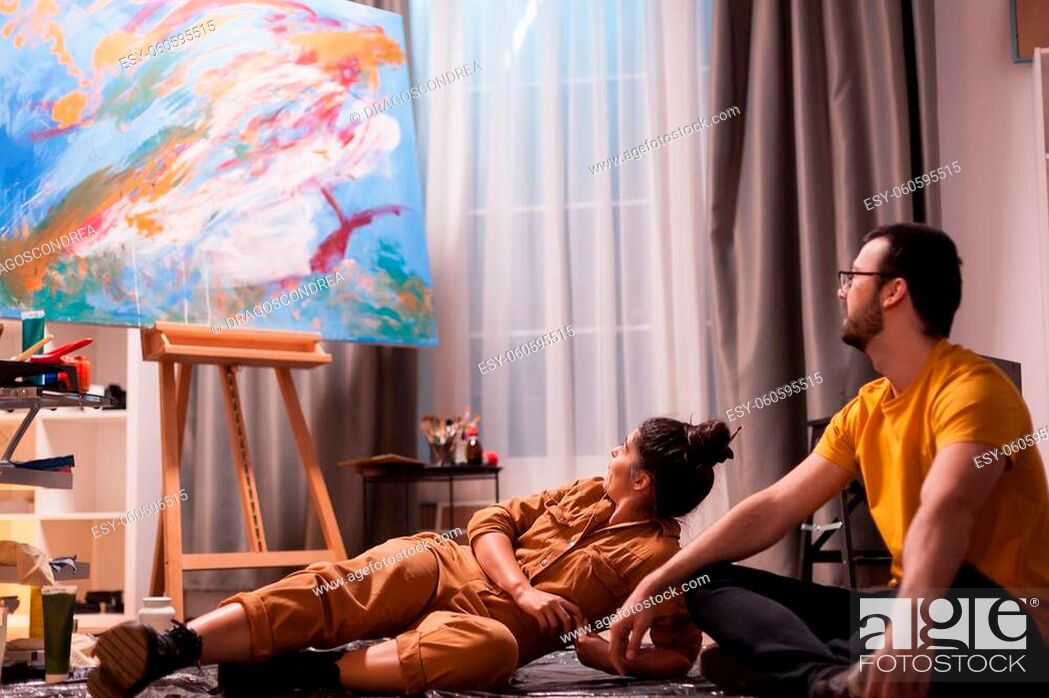 Stock Photo: Painter and is partner having a conversation about abstract painting on large canvas. Modern artwork paint on canvas, creative.