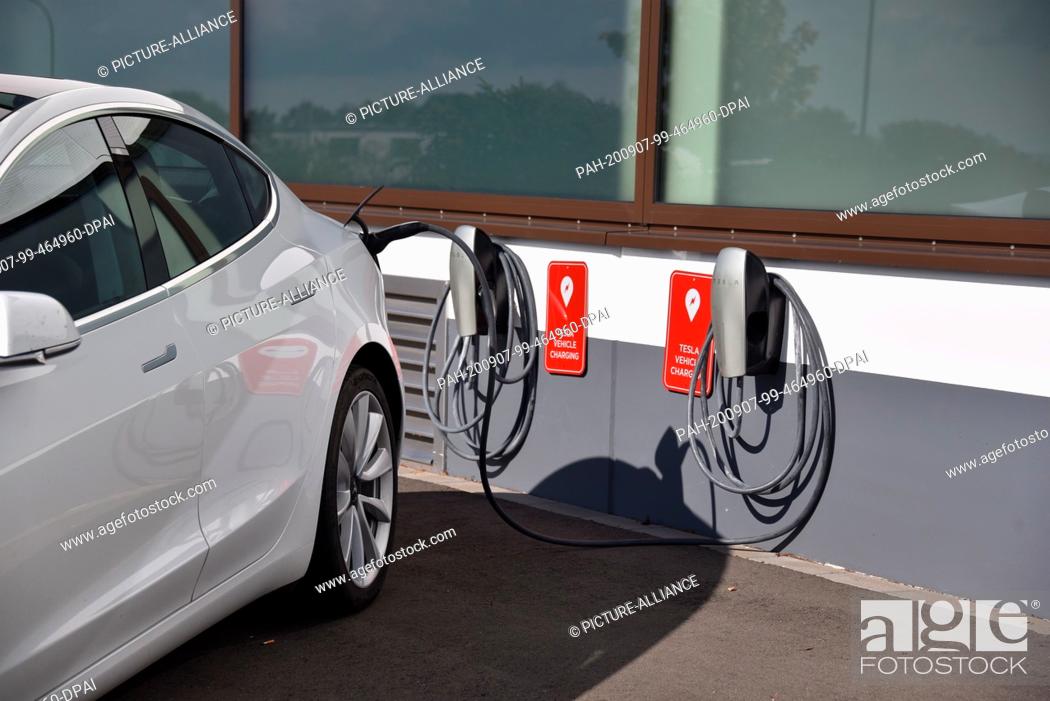 Stock Photo: 06 September 2020, Rhineland-Palatinate, Prüm: A Tesla Model 3 is charged at the charging station for TESLA electric vehicles, manufacturer of electric vehicles.