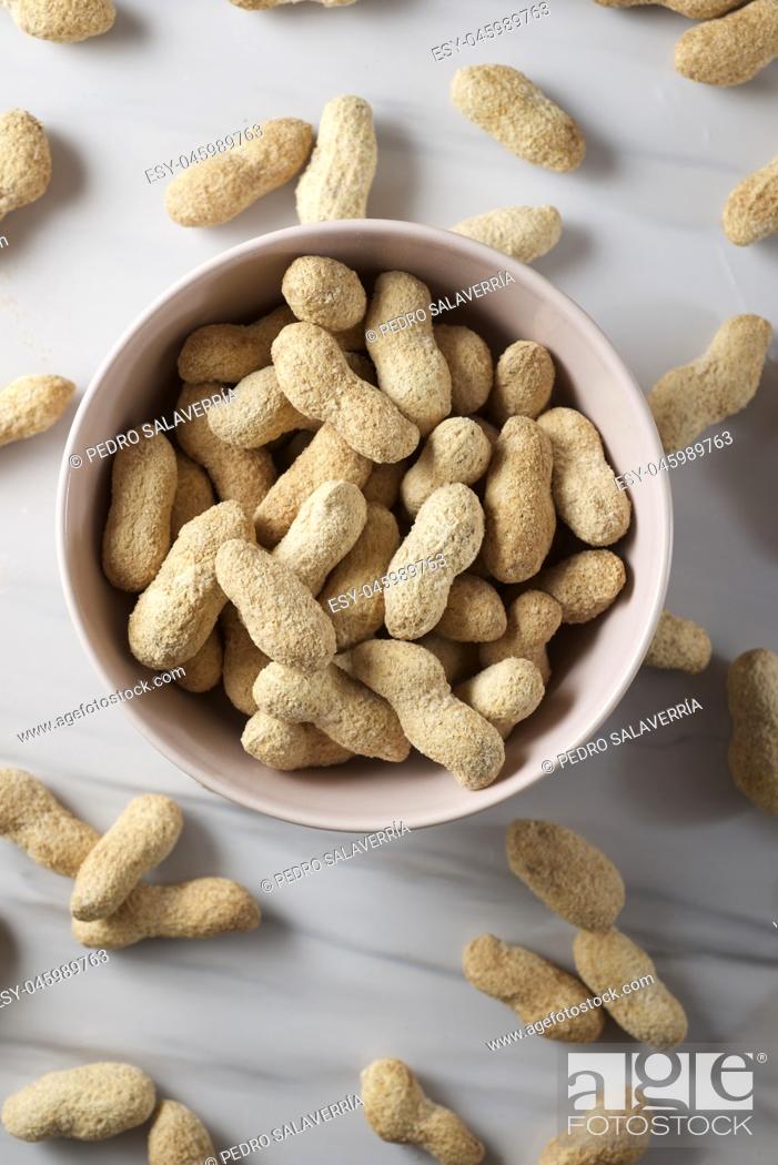 Stock Photo: Peanuts with shell on a table.