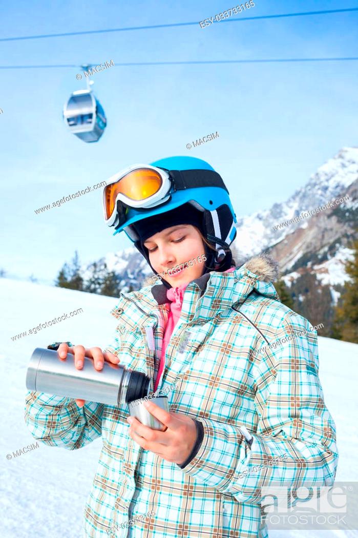 Stock Photo: Ski, skier, winter. Lovely girl has a fun on ski - resting and drinking tea from a thermos.