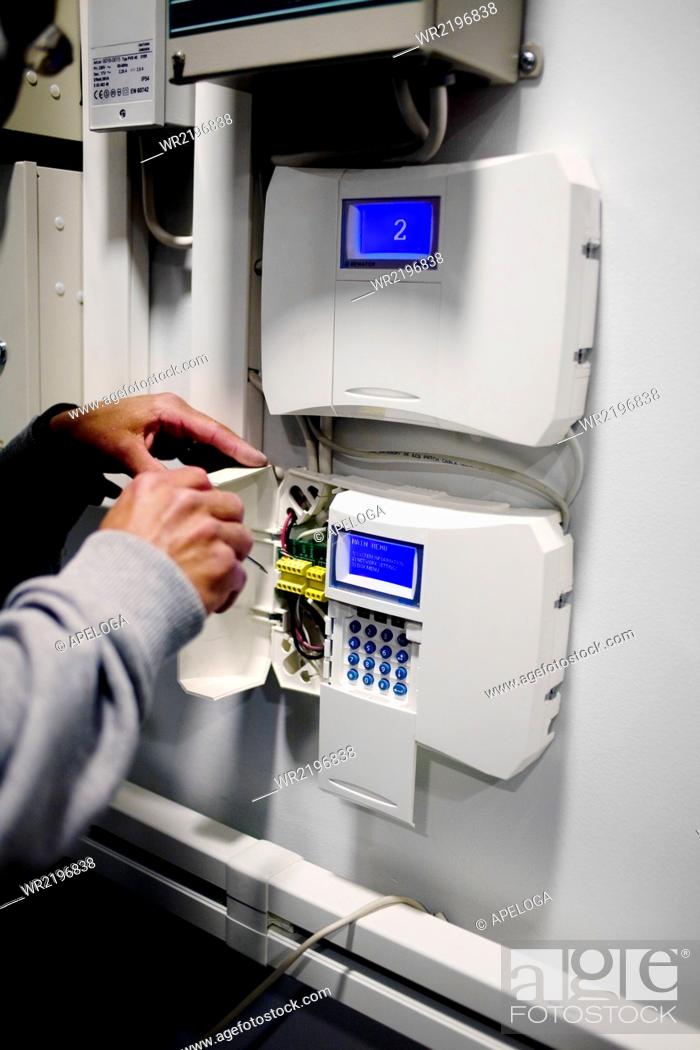 Stock Photo: Electrician repairing access control system.