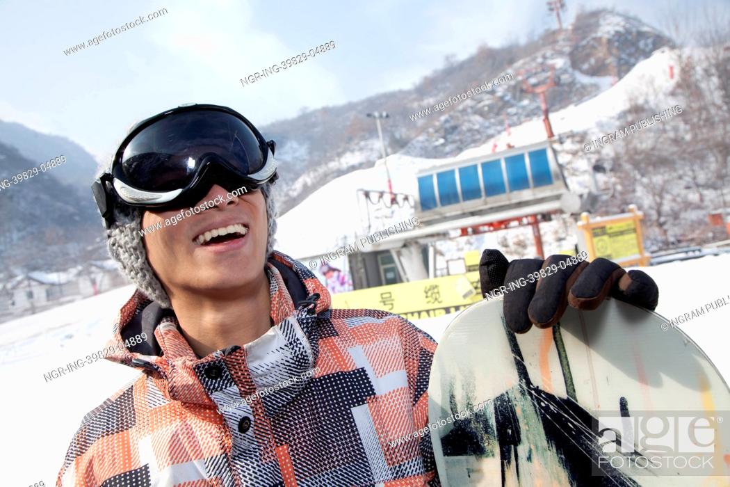 Stock Photo: Smiling Snowboarder in Ski Resort.