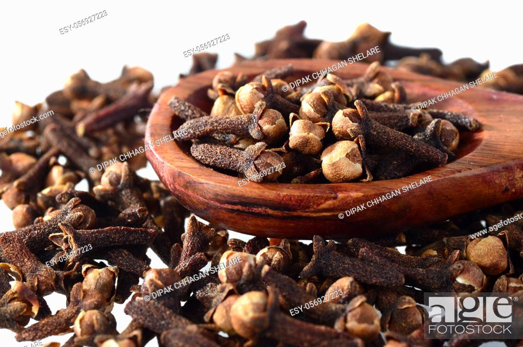 Stock Photo: Cloves (spice) and wooden spoon close-up food background. Isolated on white background.