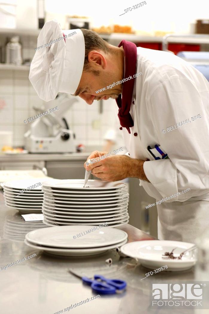 Stock Photo: Chef decorating plate with chocolate piping.