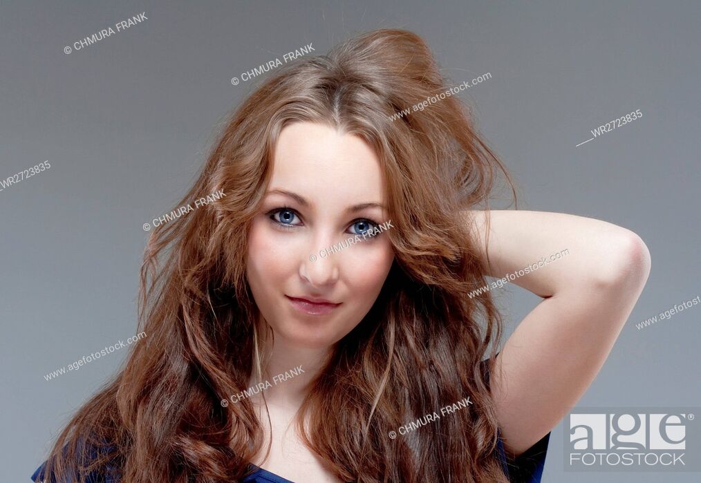 Stock Photo: portrait of a young beautiful woman with brown hair - isolated on gray.