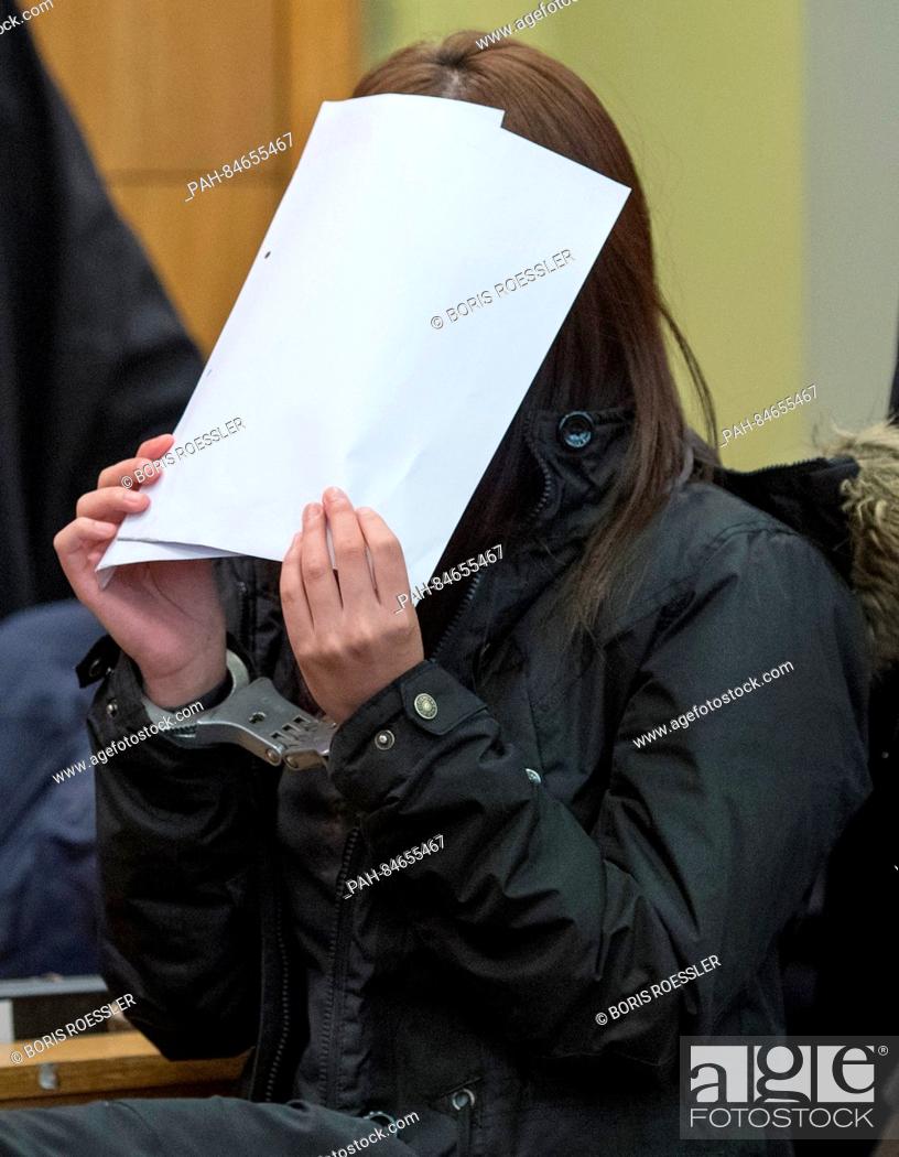 Stock Photo: A defendant arrives in a courtroom while covering her face with a folder in Frankfurt am Main, Germany, 10 October 2016. Five South Korean nations are charged.