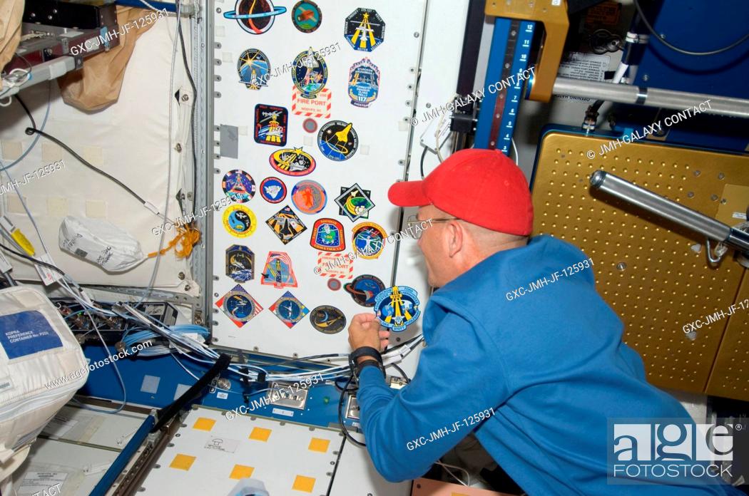 Stock Photo: NASA astronaut Rick Sturckow, STS-128 commander, adds his crew's patch to the growing collection, in the Unity node, of insignias representing crews who have.