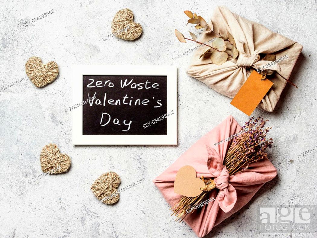 Imagen: Zero waste Valentine's Day concept. Eco-friendly gift cloth wrapping in Furoshiki style and chalkboard with Zero Waste Valentine's Day letters on gray textured.